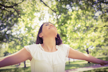 Woman holding arms wide and looking up