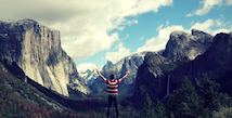 Man looking over mountain range with arms wide open