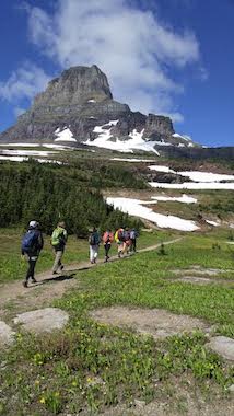 Groups of people hiking across mountain side