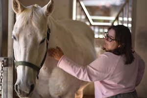 A woman petting a horse