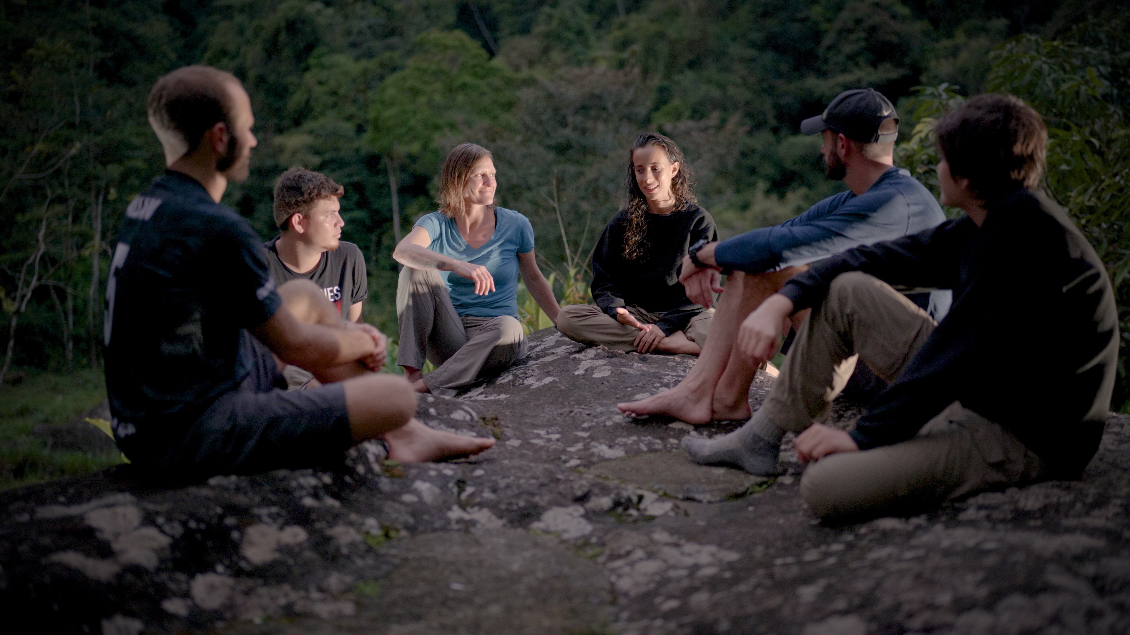 Group of teens in therapy sitting around a camp fire