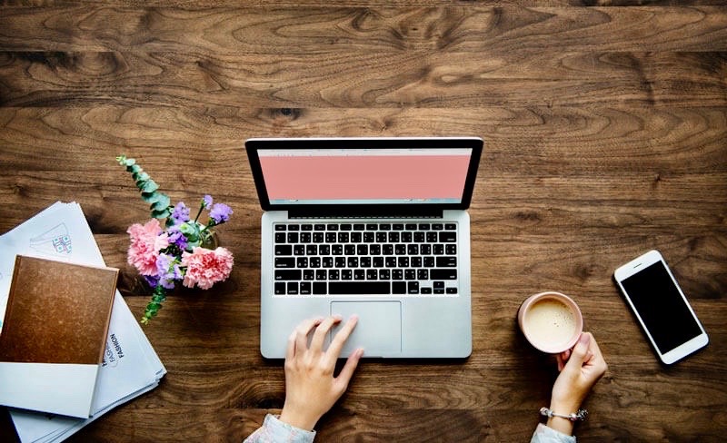 Woman working at her laptop with morning coffee