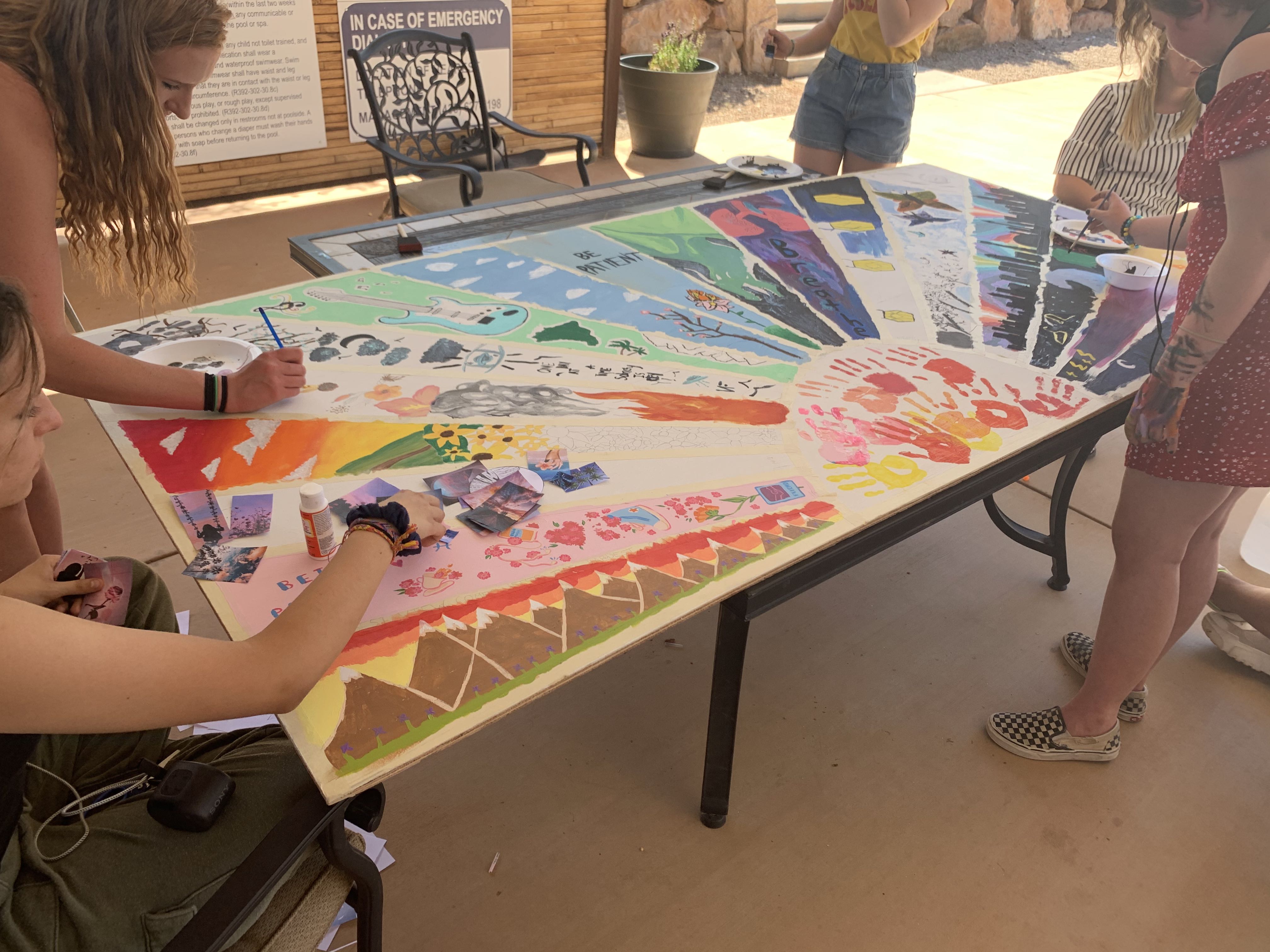 Teens contributing to a poster commemorating 20 years
