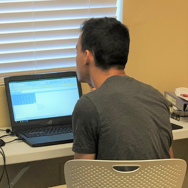 photograph of the winner looking at a computer with his back to the photo.