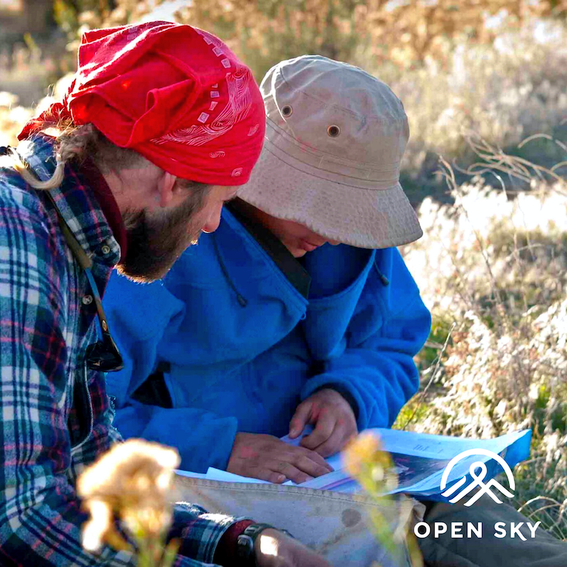 photo of two young adults looking at something and the Open Sky logo in bottom right corner.
